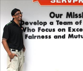 Tech standing in front of our mission statement